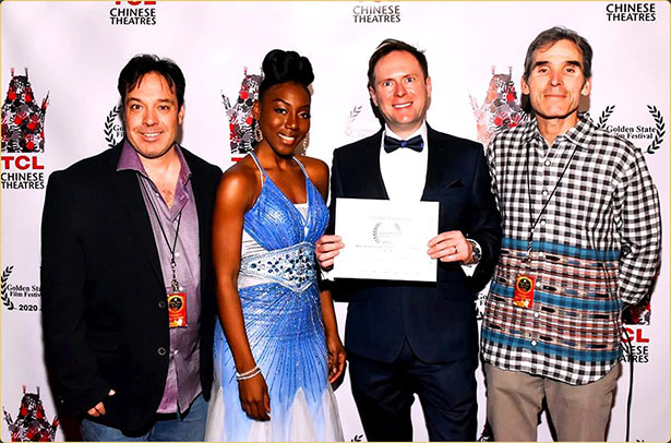 Arek Zasowski receiving award for Best International Romantic Comedy Short at Golden State Film Festival 2020 at TCL Chinese Theatre, pictured with Jon Grusha, Aemy NiaFeliz, and Peter Greene