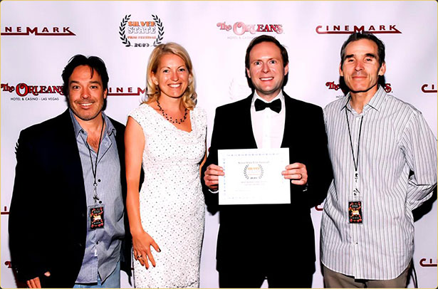 Arek Zasowski holding his award for Best Inspirational Short at the Silver State Film Festival for Let Go: The Prelude, on the red carpet in Las Vegas with Viola Zasowska, Jon Grusha, and Peter Greene