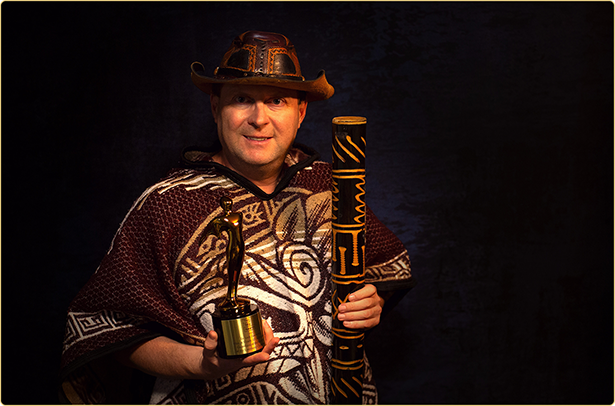 Arek Zasowski holding Gold Telly Award statuette and jungle-inspired prop, award-winning actor director producer of Guardians of the Secrets of the Luminara Challenge